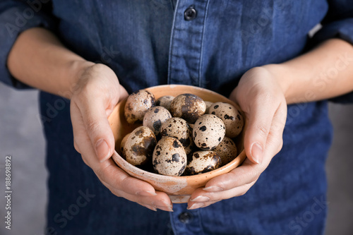 Woman holding bowl with quail eggs, closeup