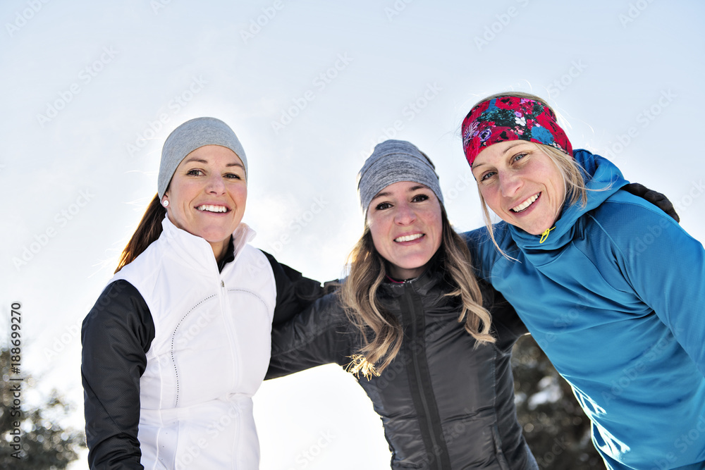 Group of friends enjoying jogging in the snow in winter Group of friends enjoying jogging in the snow in winter