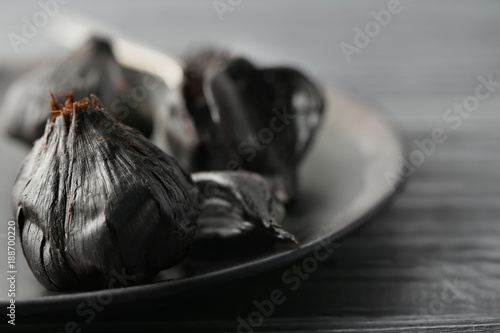 Plate with black garlic (Allium sativum), closeup