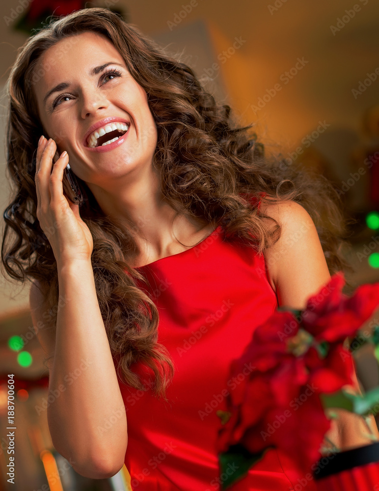Happy young housewife talking phone in christmas decorated kitchen Happy young housewife talking phone in christmas decorated kitchen