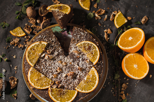 Beautiful and tasty chocolate cake with orange and nut on a dark background