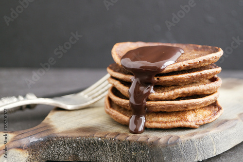 Chocolate pancakes with chocolate sauce on a dark background.