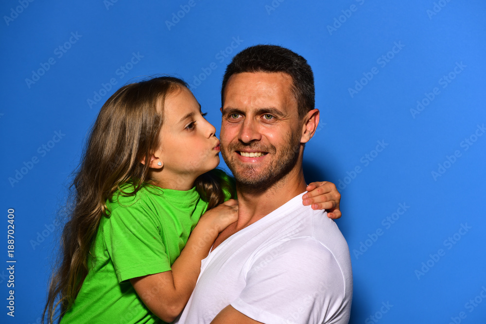Childhood and family relationship concept. Daughter kisses her daddy Childhood and family relationship concept. Daughter kisses her daddy