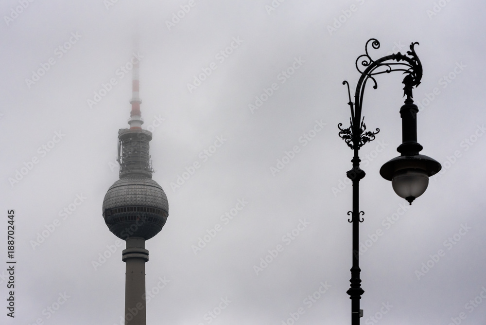 Old and new Berlin TV tower (Fernsehturm) and a street lamp in deep fog - landmark of Germany capital