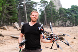 Mann mit Drohne Multikopter in der Hand