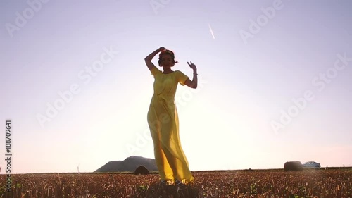 beautiful woman in a transparent dress dancing at sunset