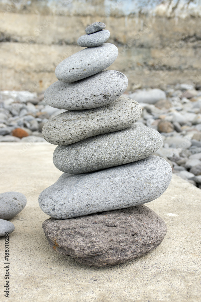 Stone cairn tower, poise stones, rock zen sculpture, light grey pebbles Stone cairn tower, poise stones, rock zen sculpture, light grey pebbles