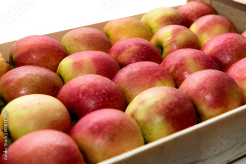 wooden crate with red and yellow apples, on white background