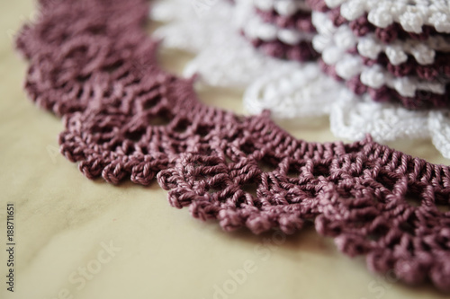 White and purple hand hooked coaster. Knitted holders for hot work
