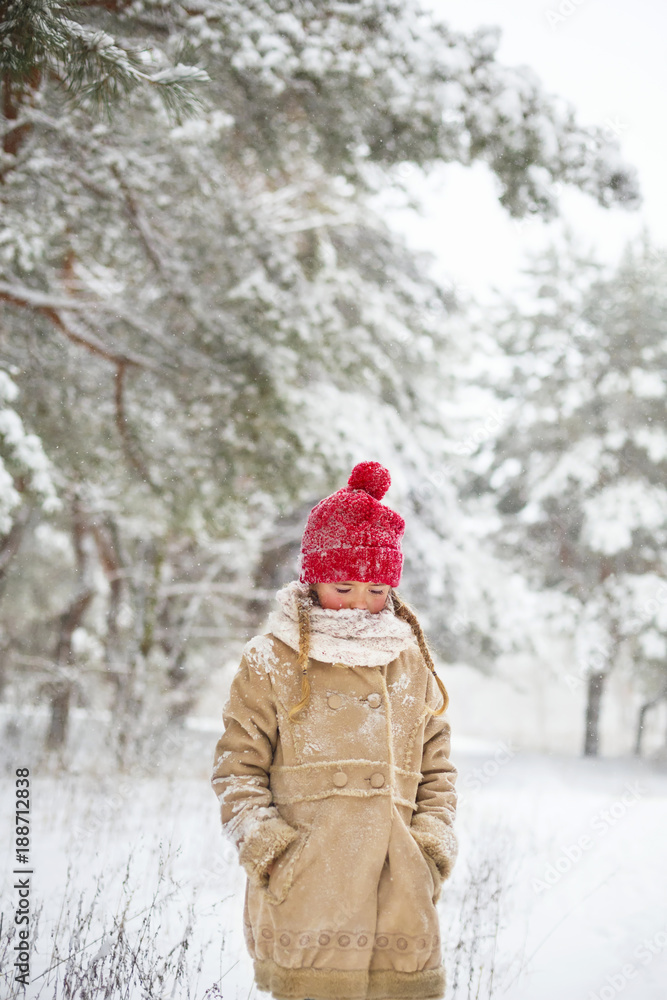 Beautiful girl walk in snowy winter forest. Little child wearing a red knitted gloves and jacket play outdoor at Christmas holiday. Family winter vacation with kids in mountains Beautiful girl walk in snowy winter forest. Little child wearing a red knitted gloves and jacket play outdoor at Christmas holiday. Family winter vacation with kids in mountains