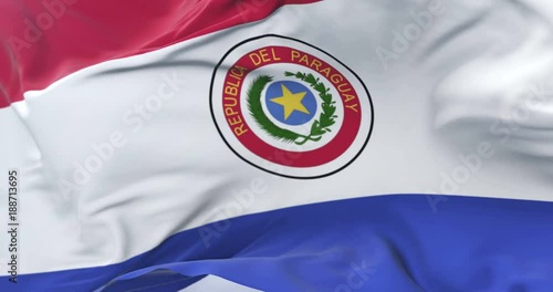 Flag of Paraguay waving at wind with blue sky in slow, loop photo