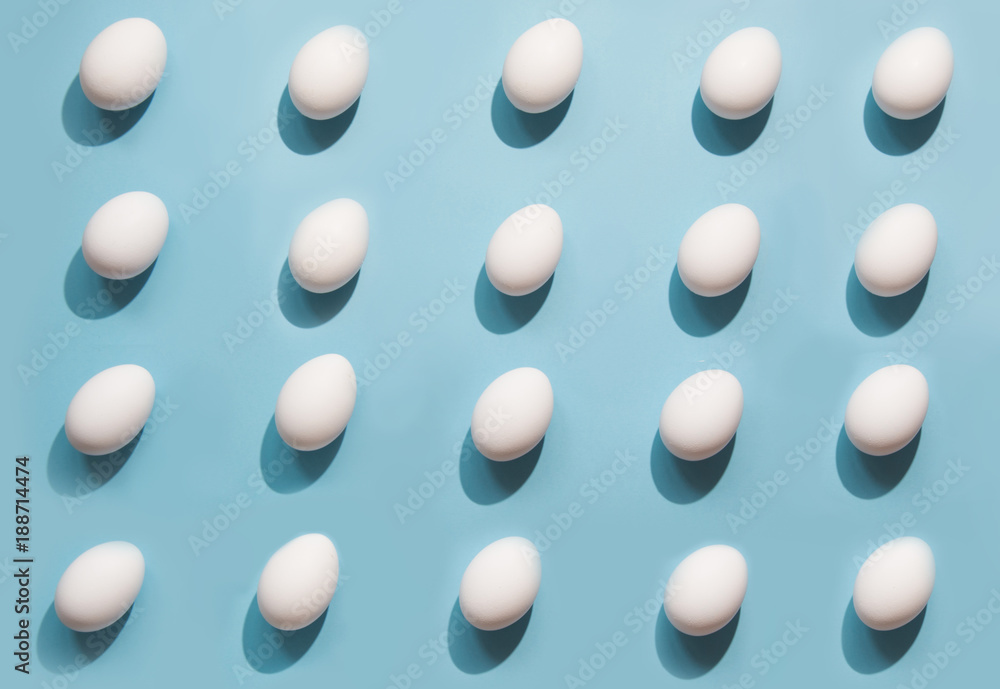 Organic white eggs on blue. Abstract pattern. Eggs in isometric.