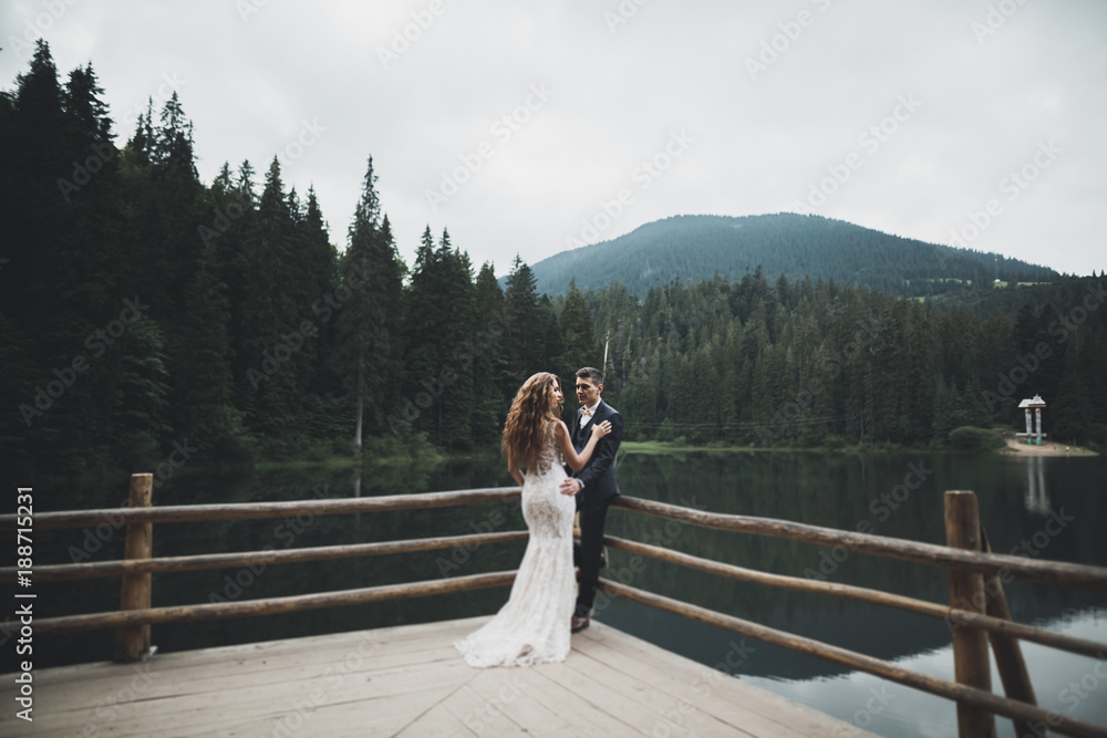 Beautifull wedding couple kissing and embracing near mountain with perfect view