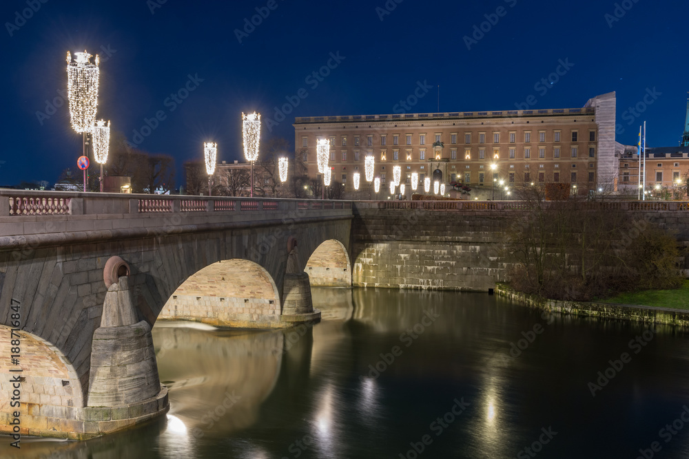 Naklejka premium Strömbron vackert upplyst av julbelysning som leder till Stockholm slott