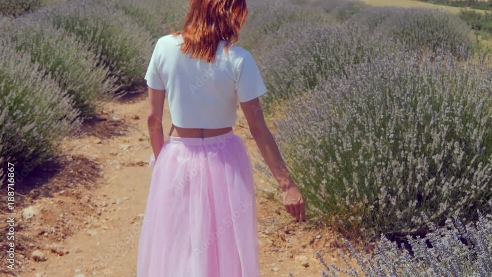 Young woman walking in the lavender field Young woman walking in the lavender field