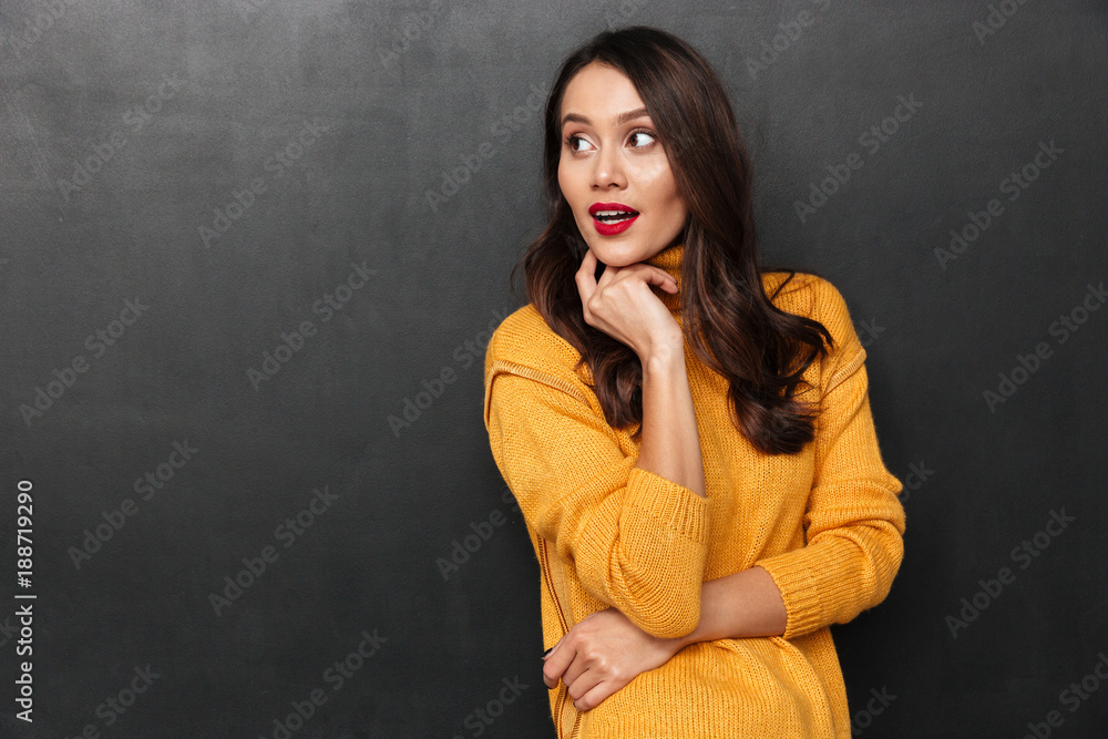 Pretty brunette woman in sweater posing and looking away Pretty brunette woman in sweater posing and looking away