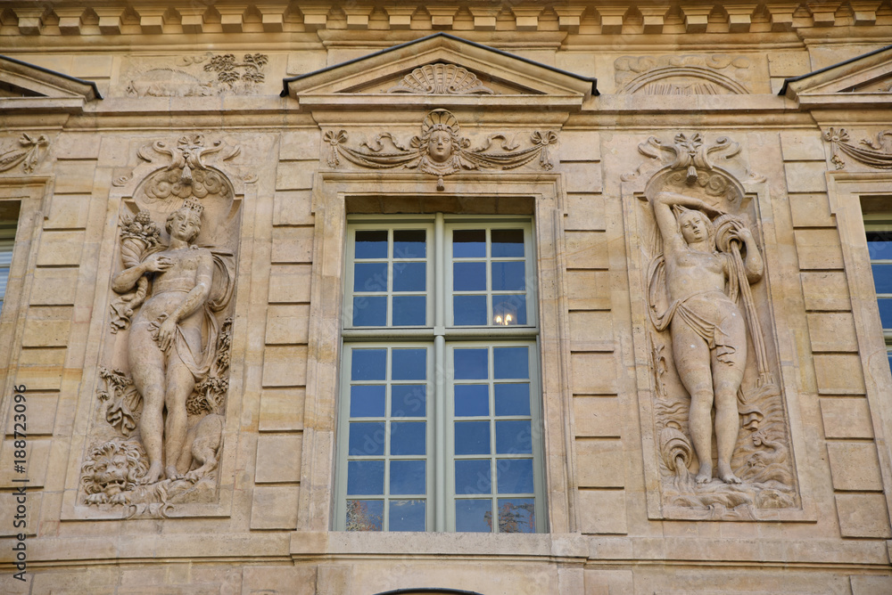 Façade de palais ornée de statues de femmes dans le Marais à Paris, France