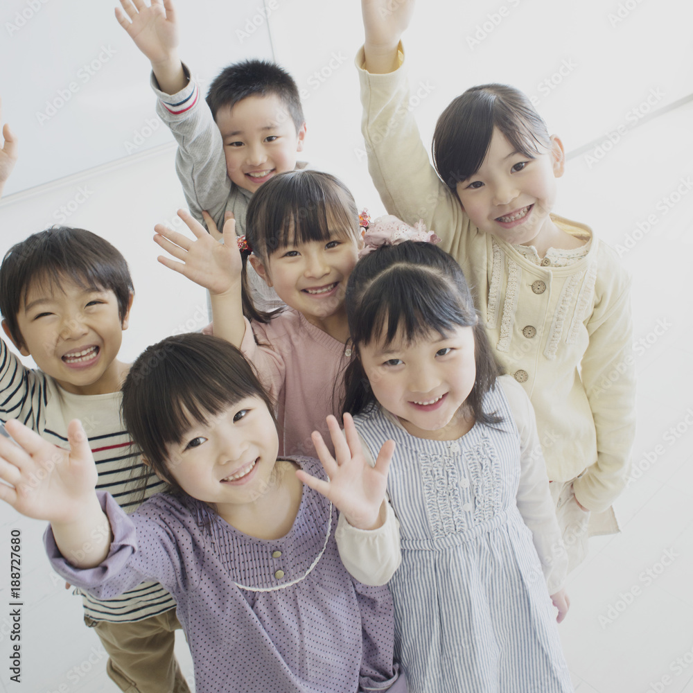 Portrait of group of smiling children with raised hands Portrait of group of smiling children with raised hands