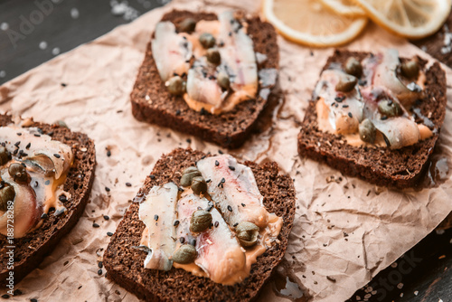 bruschetta with delicious fish on a cream cushion with capers and olive oil