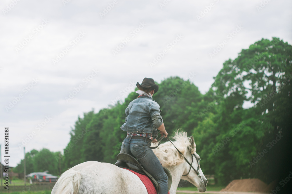 Woman cowboy gallops on horseback