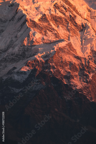 Mountain in Himalayas glowing orange at sunrise