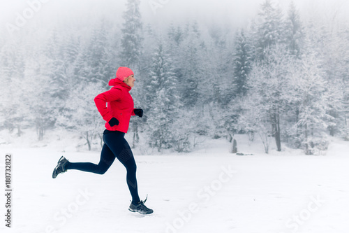 Girl running on snow in winter mountains