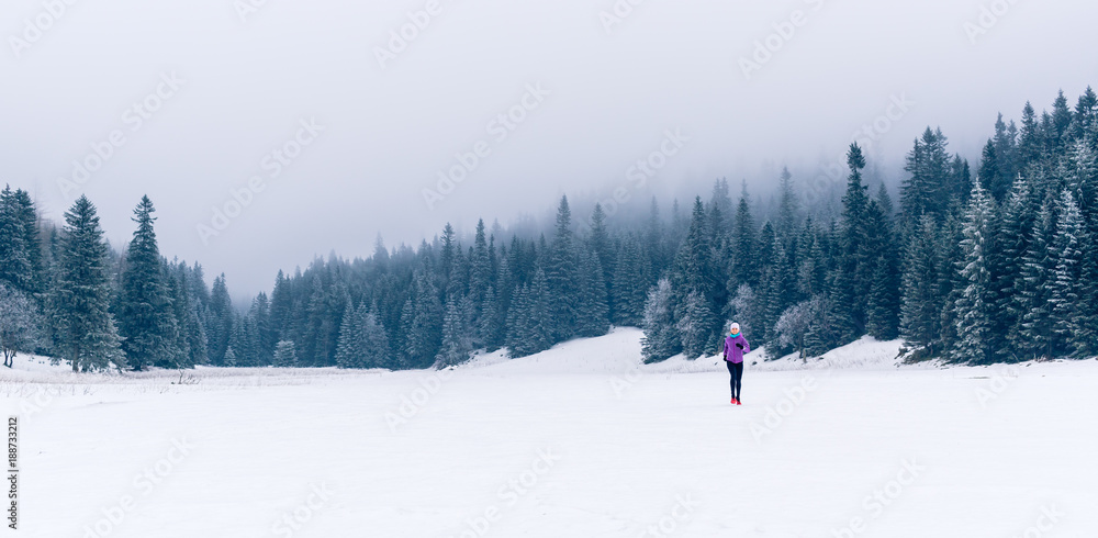 Woman running on winter trail, fitness inspiration and motivation