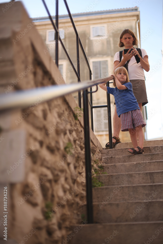 A man with a camera and a small son on the street of the old city. Zagreb, Croatia.