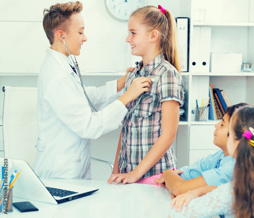 Fototapeta premium Young male doctor in uniform with children
