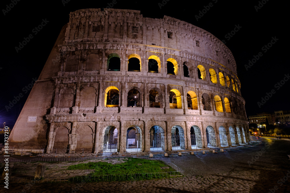 Illuminated Colosseum in Rome at night. Ruins of the  ancient Roman amphitheatre. Travel to Italy, Europe.