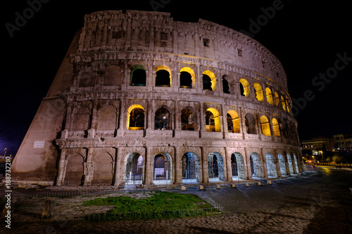 Illuminated Colosseum in Rome at night. Ruins of the ancient Roman amphitheatre. Travel to Italy, Europe.