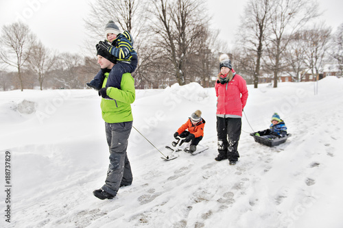 Family Pulling Sledge Through Snowy Landscape photo