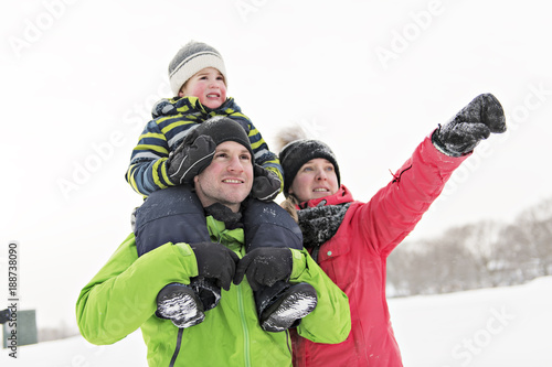 family and child spending time outdoor in winter photo