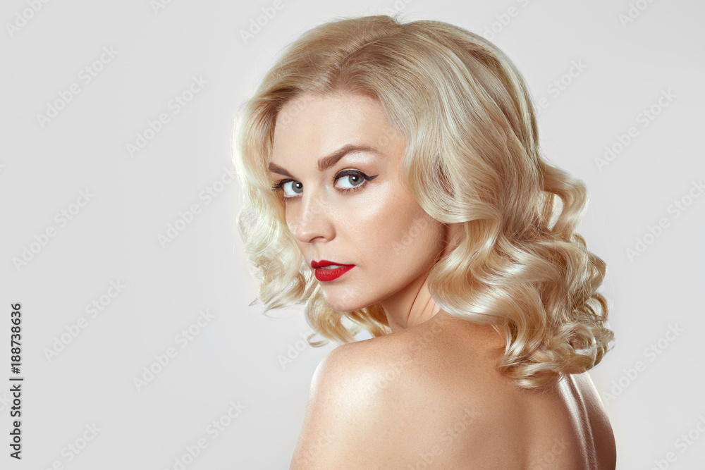Naklejka premium Portrait of beautiful blonde girl with curly hair, cat eye make-up, red lips. Concept mock up photo.