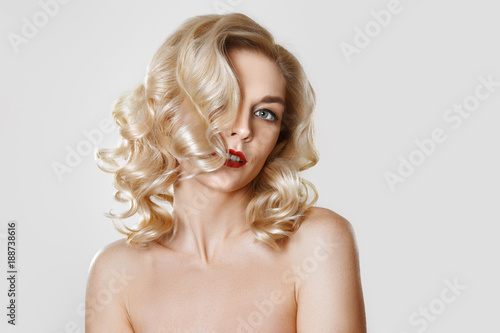 Portrait of beautiful blonde girl with curly hair, cat eye make-up, red lips. Concept mock up photo.