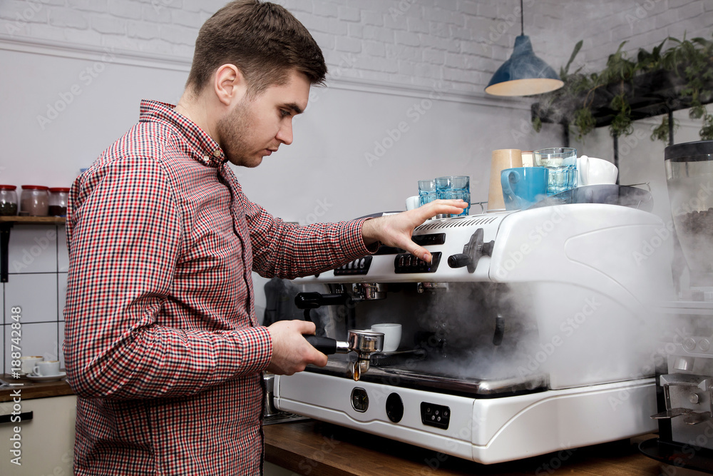 Young handsome barista hipster making coffee cafe man machine grains hot steam milk shirt cage espresso latte cappuccino Young handsome barista hipster making coffee cafe man machine grains hot steam milk shirt cage espresso latte cappuccino