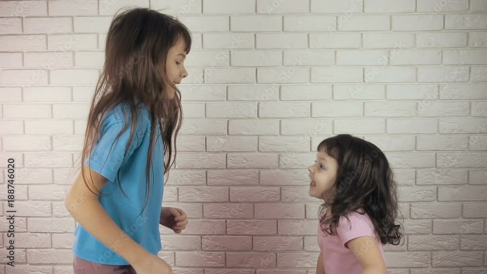 Happy children jumping against a brick wall background. Happy children jumping against a brick wall background.