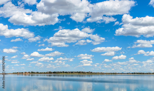 Canvas Print Spring Clouds - White spring clouds, on blue sky, rolling pass a city lake