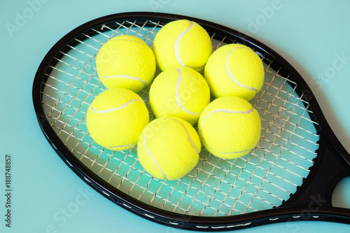 Tennis balls on racket. Blue background. Concept sport. Close up.