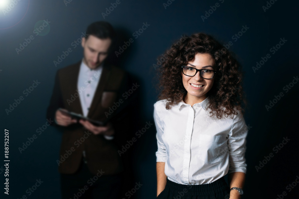 Plakat the woman is the leader in the team. curly brunette with glasses