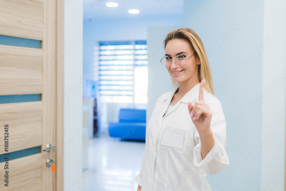smiling medical doctor woman standing at hospital hall