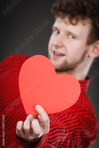 Cheerful man holding heart.