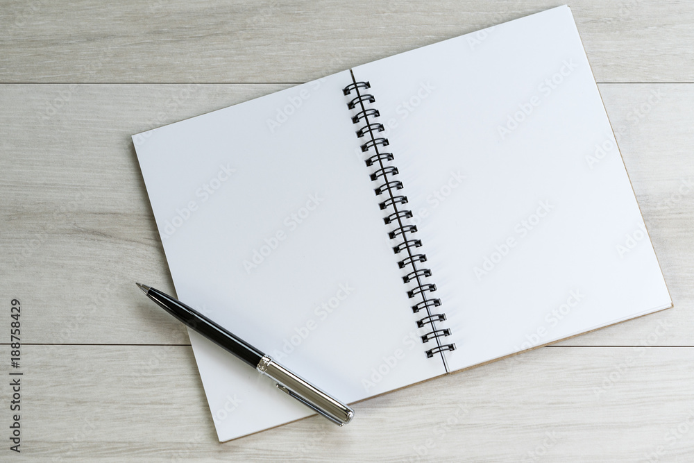 Opening white blank note paper and pen on the left with on light grey wooden table background with copy space Opening white blank note paper and pen on the left with on light grey wooden table background with copy space