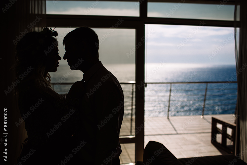 bride and groom silhouette against the sea