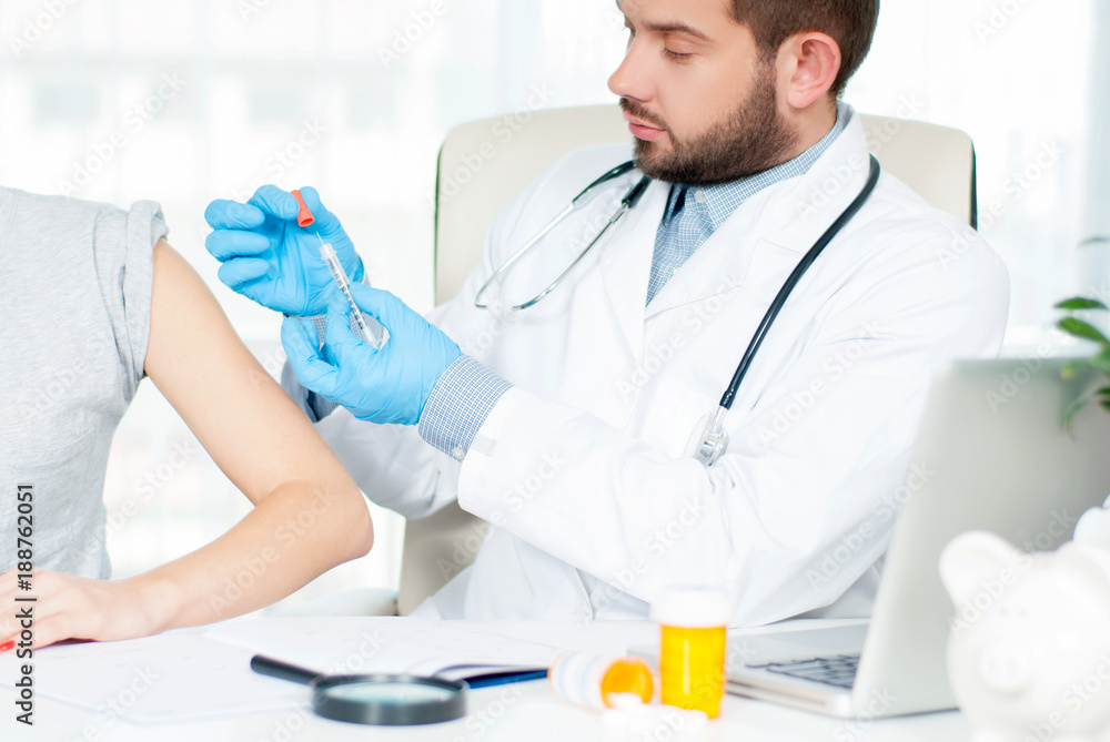 Vaccination. Flu shot. Doctor injecting flu vaccine to patient's arm Vaccination. Flu shot. Doctor injecting flu vaccine to patient's arm