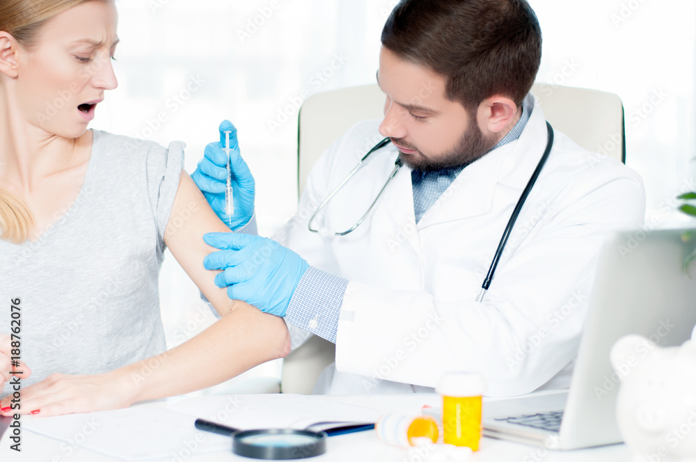 Vaccination. Flu shot. Doctor injecting flu vaccine to patient's arm Vaccination. Flu shot. Doctor injecting flu vaccine to patient's arm