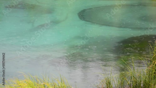Rain drops on water. blue geyser lake in Altay mountains. Siberia. Russia.