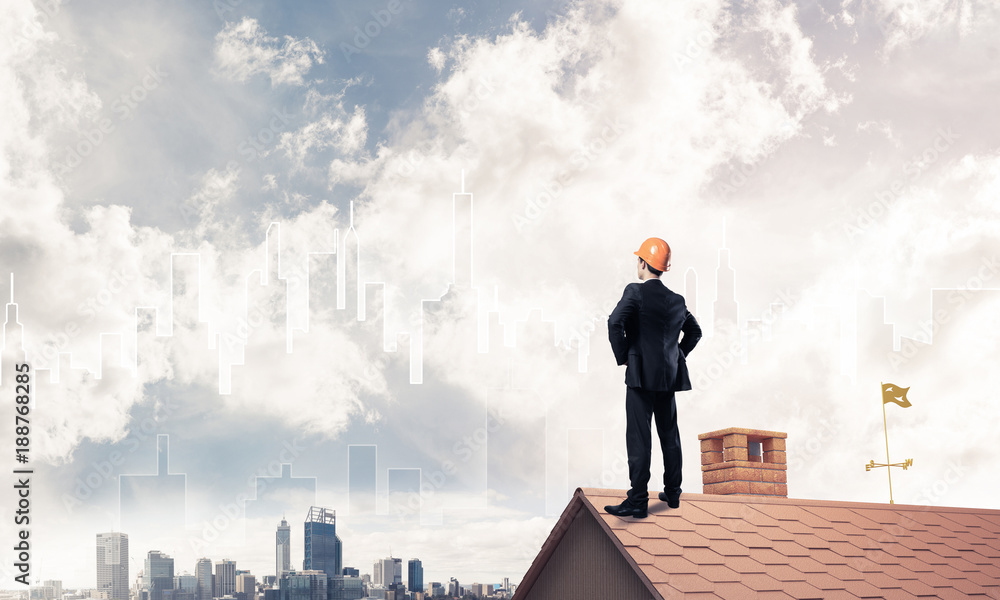 Engineer man standing on roof and looking away. Mixed media Engineer man standing on roof and looking away. Mixed media