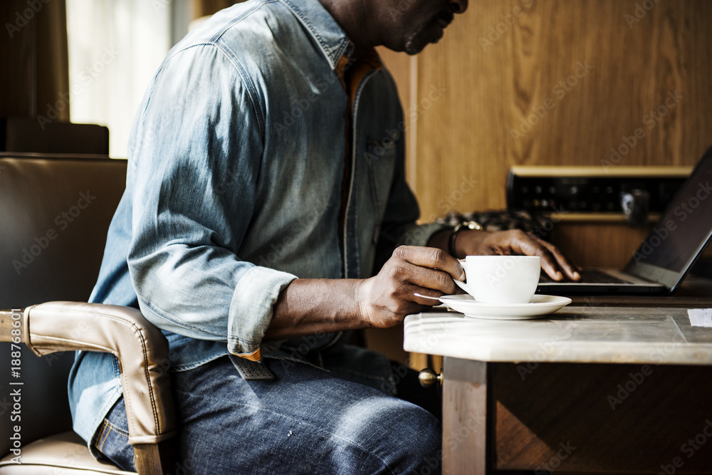 Man working on laptop and having a hot drink
