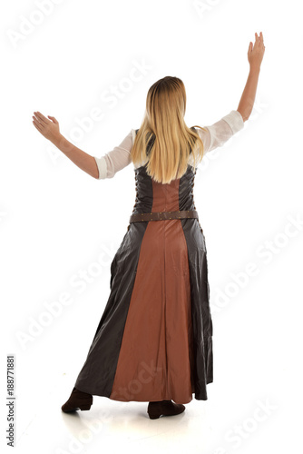 full length portrait of girl wearing brown fantasy costume, standing pose with back to the camera on white studio background. 